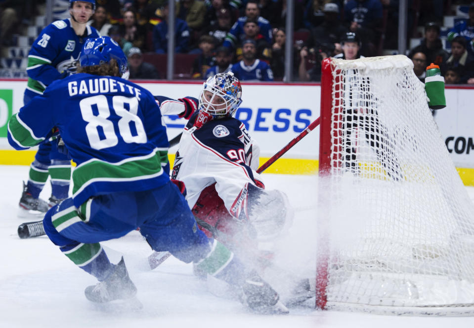 Vancouver Canucks center Adam Gaudette (88) fails to get a shot past Columbus Blue Jackets goaltender Elvis Merzlikins (90) during the second period of an NHL hockey game in Vancouver, British Columbia, Sunday, March 8, 2020. (Jonathan Hayward/The Canadian Press via AP)
