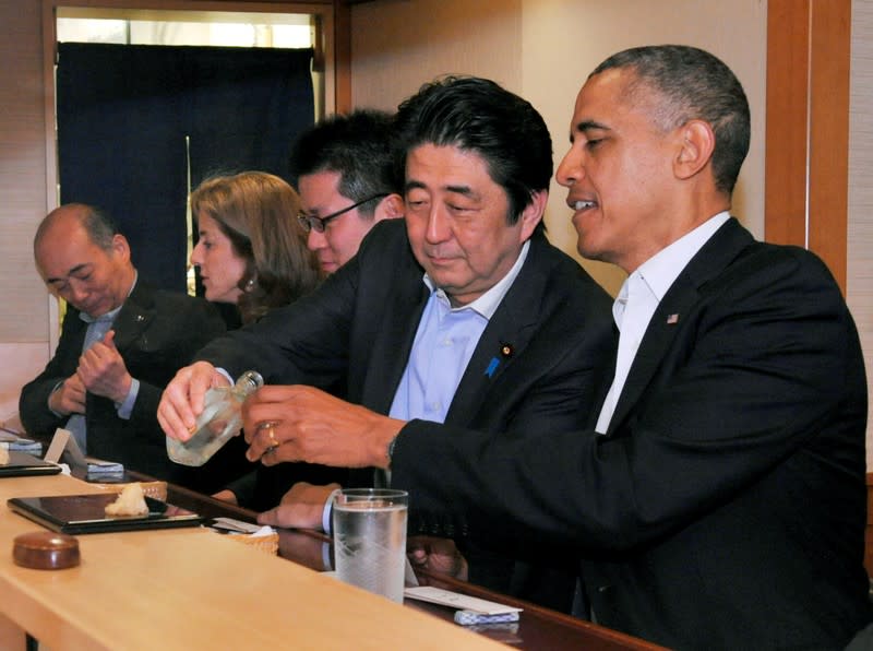 FOTO DE ARCHIVO. El primer ministro japonés, Shinzo Abe, sirve sake al presidente estadounidense Barack Obama durante una cena en el famoso restaurante Sukiyabashi Jiro en Tokio. Imagen tomada en abril de 2014. Office/Handout via Reuters/File Photo. ATENCIÓN EDITORES: ESTA IMAGEN FUE PROVISTA POR UNA TERCERA PARTE.