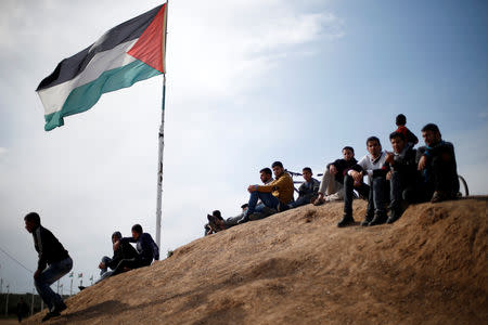 Palestinian sit near to the Israeli-Gaza border fence, ahead of the first anniversary of border protests, east of Gaza City March 29, 2019. REUTERS/Mohammed Salem