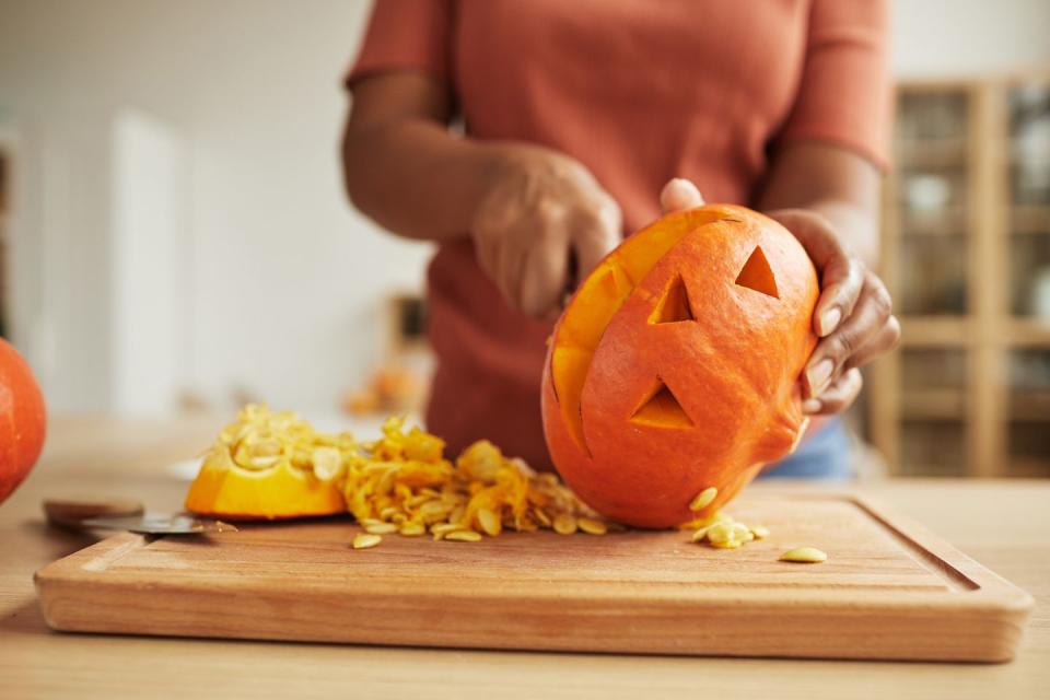 carving jack o lantern out of ripe orange pumpkin