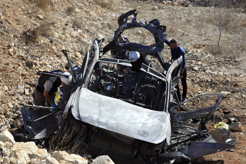 Civil Defense workers inspect the damaged car that hit by an Israeli airstrike in the town of Ainata, a Lebanese border village with Israel in south Lebanon, Monday, Nov. 6, 2023. An Israeli airstrike in south Lebanon on Sunday, Nov. 5, 2023 evening killed four civilians, including a woman and three children, raising the likelihood of a dangerous new escalation in the conflict on the Lebanon-Israel border. (AP Photo/Mohammed Zaatari)