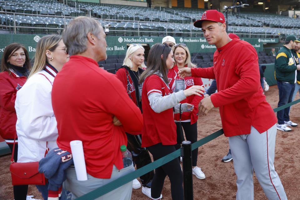 Los Angeles Angels catcher Logan O'Hoppe, right, greets friends and family prior to the team's opening day baseball game against the Oakland Athletics in Oakland, Calif., Thursday, March 30, 2023. (AP Photo/Jed Jacobsohn)