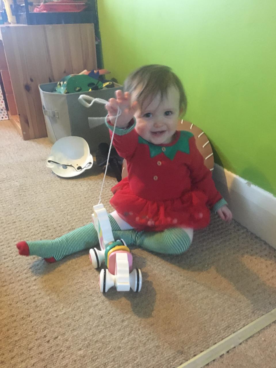 Sofia playing with her toy, dressed in Christmas colours. (PA Real Life)
