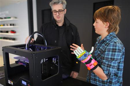 Twelve-year-old Leon McCarthy (R) talks about a MarkerBot Replicator 2 Desktop 3D Printer, with the company's CEO Bre Pettis, at the new MakerBot store in Boston, Massachusetts November 21, 2013. REUTERS/Brian Snyder