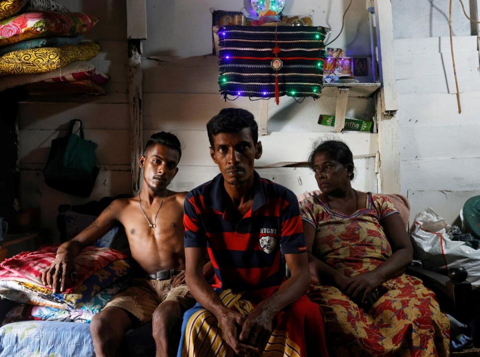 Gamage Rupawathi, right, 60, her husband WA Susantha, centre, 45, and their son, Krishan Darshana, 25, at their home. ‘When I had fruit business I was earning a significant income,’ Rupawathi says. ‘But with the drawn-out lockdowns during the pandemic and now this economic crisis I don’t have money to restart my fruit stall.’ (Reuters)