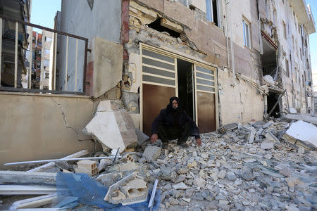 A man sits outside a damaged belonging following an earthquake in Sarpol-e Zahab county in Kermanshah, Iran. REUTERS/Tasnim News Agency