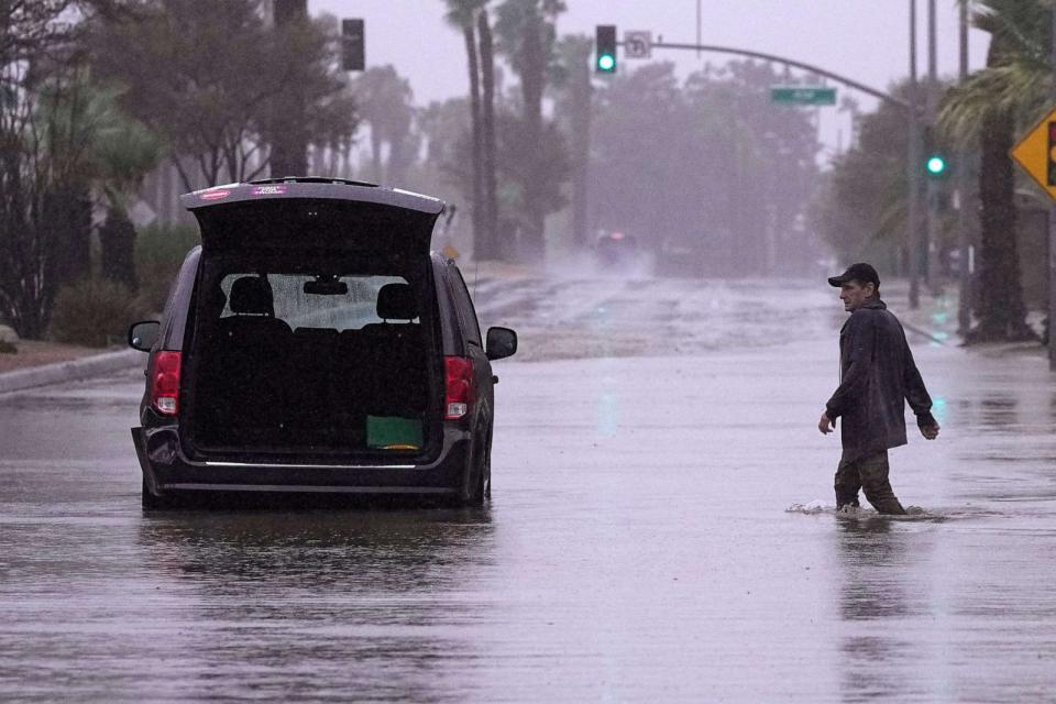 PHOTO: A motorist walks out to remove belongings from his vehicle after becoming stuck in a flooded street, Sunday, Aug. 20, 2023, in Palm Desert, Calif. (Mark J. Terrill/AP)