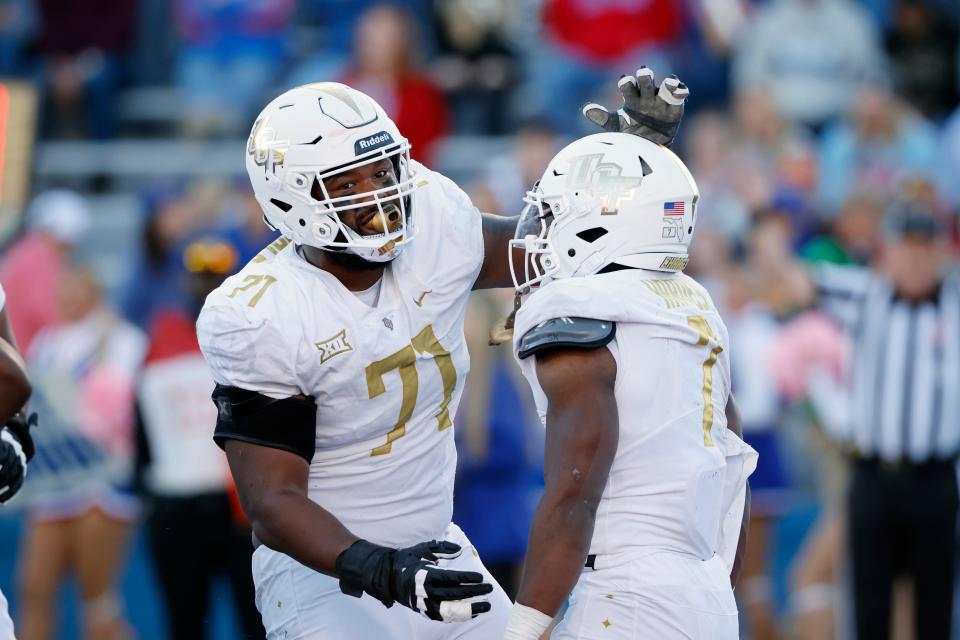 Central Florida offensive lineman Tylan Grable (71) congratulates UCF running back RJ Harvey (7), who scored a touchdown against Kansas during the second half of an NCAA college football game Saturday, Oct. 7, 2023, in Lawrence, Kan. (AP Photo/Colin E. Braley)