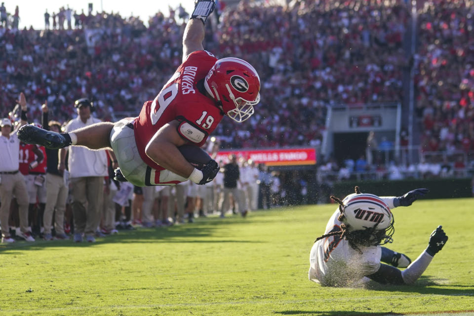 Georgia tight end Brock Bowers (19) dives past Tennessee-Martin safety Oshae Baker (0) to score on a short run during the first half of an NCAA college football game Saturday, Sept. 2, 2023, in Athens, Ga. (AP Photo/John Bazemore)