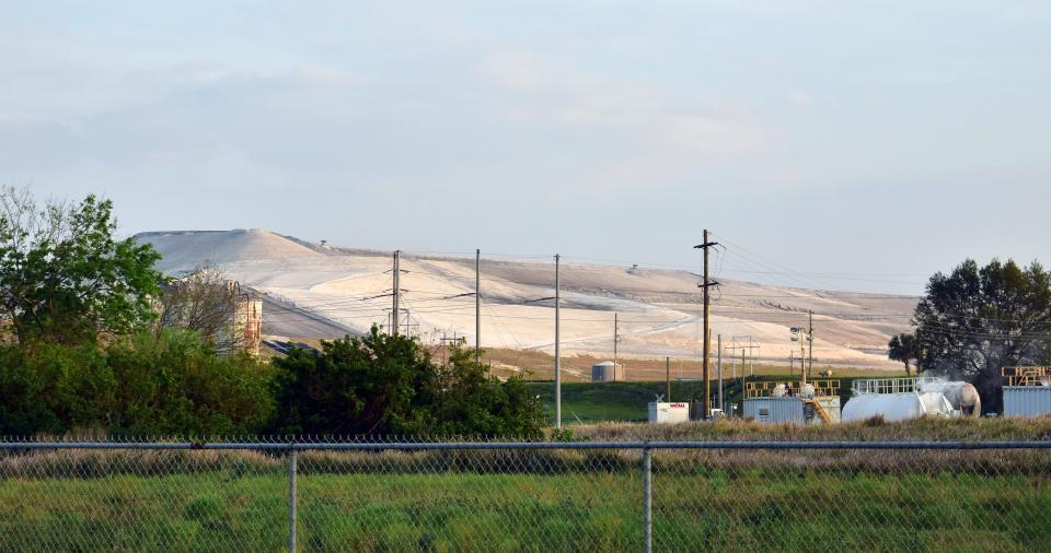 A Mosaic phosphogypsum stack stands behind a fence in Bartow, Fla. on Friday, Feb. 24, 2023.