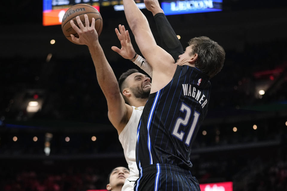 Cleveland Cavaliers guard Max Strus, left, shoots as Orlando Magic center Moritz Wagner defends during the second half of an NBA basketball game Thursday, Feb. 22, 2024, in Cleveland. (AP Photo/Sue Ogrocki)