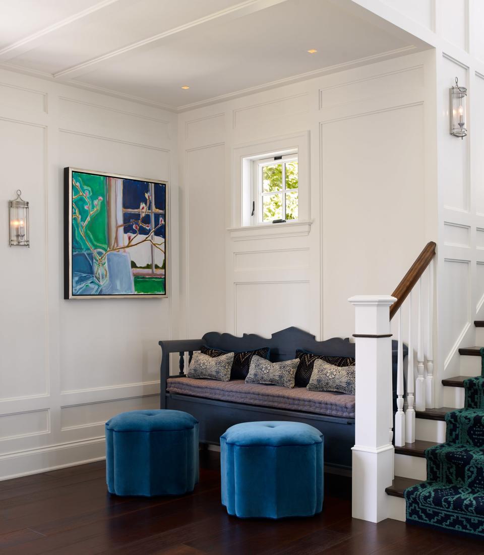 For the entry, Lippmann added an antique pine bench that her colleague Chloe Kregling found at a local shop, and painted it Hague Blue by Farrow & Ball. The color of the wood paneling is Pointing by Farrow & Ball. Hudson Valley Lighting did the sconces.