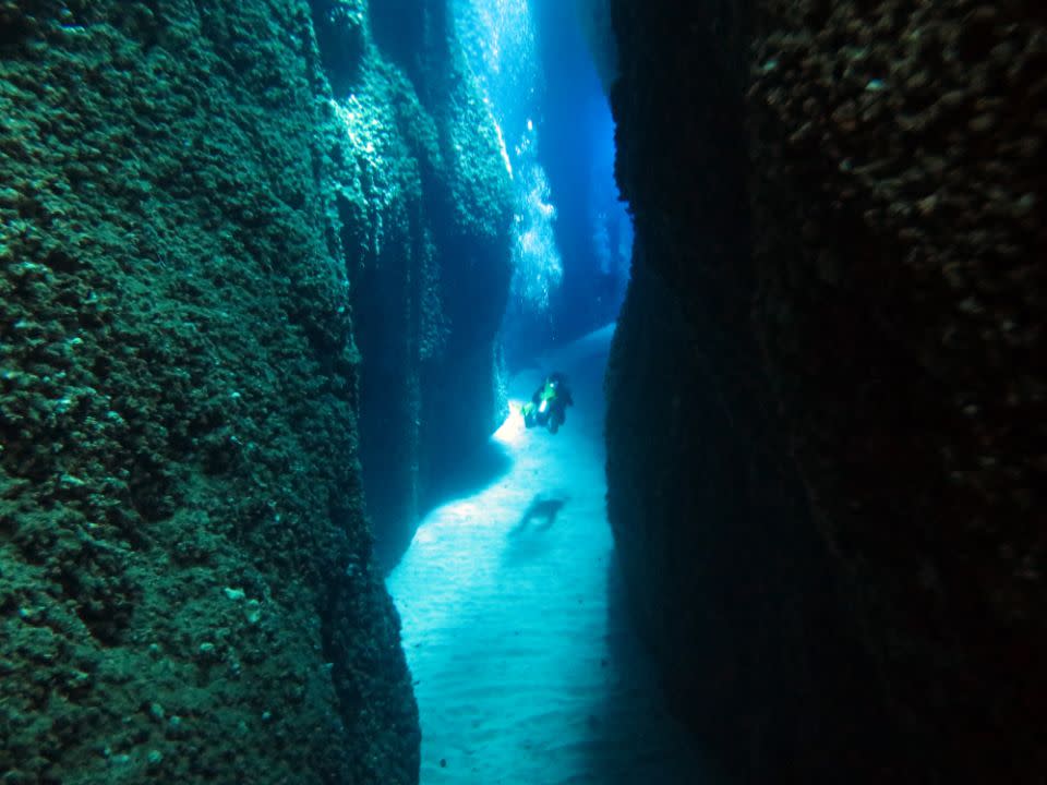 Blue light is seen penetrating through an opening crevice at the Leru Cut. Source: Dive Planit