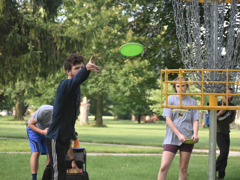 Adrian resident Liam Foreman makes a putt during a disc golf match Thursday with the Adrian Orbit Disc Golf Club on the PlaneWave Instruments course.