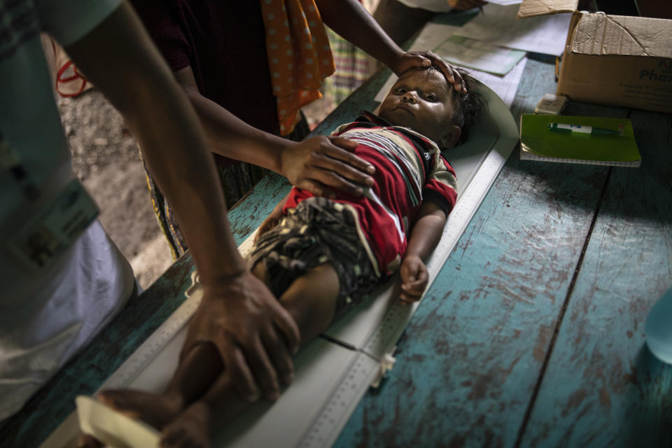 Sergio David Jom, 2, lies on a scale as he is measured during a wellness checkup in the makeshift settlement Nuevo Queja, Guatemala, Friday, July 9, 2021. At least once a month, a nurse visits Nuevo Queja. The results are bad. "Malnutrition has doubled. One in three are stunted," said head nurse Cesar Chiquin. (AP Photo/Rodrigo Abd)