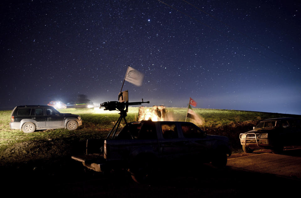 In this photo taken late Friday, Dec. 28, 2018, Turkey-backed Free Syrian Army soldiers wait stationed near the northern Syrian city of Manbij. Syria's military announced Friday that it entered the flashpoint Kurdish-held town of Manbij, where Turkey has threatened an offensive and raised the national flag there. (DHA via AP)