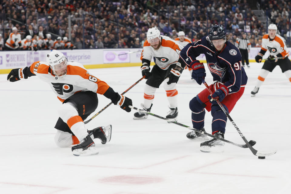 Columbus Blue Jackets' Kent Johnson, right, tries to carry the puck past Philadelphia Flyers' Justin Braun during the second period of an NHL hockey game Tuesday, Nov. 15, 2022, in Columbus, Ohio. (AP Photo/Jay LaPrete)