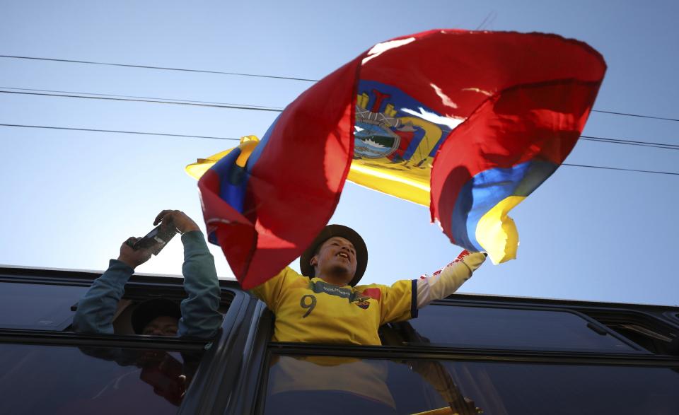 An anti-austerity protester waves a national flag as he rides away in a bus to return home, in the aftermath of violent protests against the government, in Quito, Ecuador, Monday, Oct. 14, 2019. Ecuador celebrated a deal President Lenín Moreno and indigenous leaders struck late Sunday to cancel a disputed austerity package and end nearly two weeks of protests that have paralyzed the economy and left seven dead. (AP Photo/Fernando Vergara)