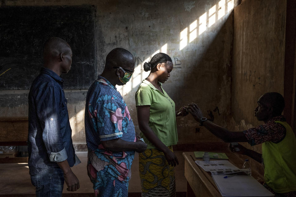 People cast their votes for presidential and legislative elections, at the Lycee Boganda polling station in the capital Bangui, Central African Republic Sunday, Dec. 27, 2020. President Faustin-Archange Touadera and his party said the vote will go ahead after government forces clashed with rebels in recent days and some opposition candidates pulled out of the race amid growing insecurity. (AP Photo)