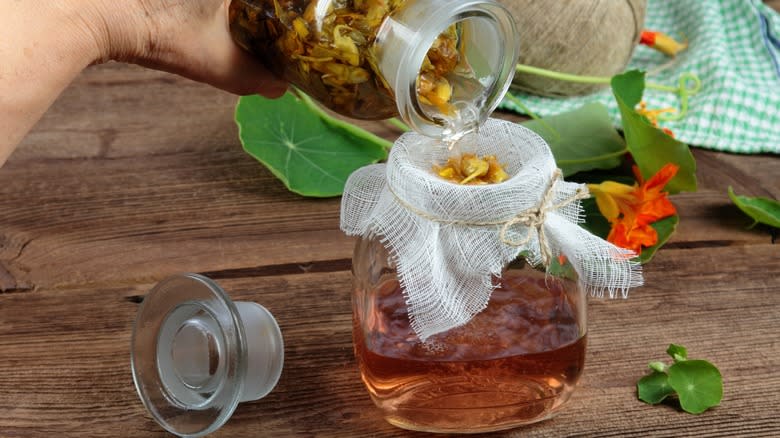 straining infused liquid into bottle