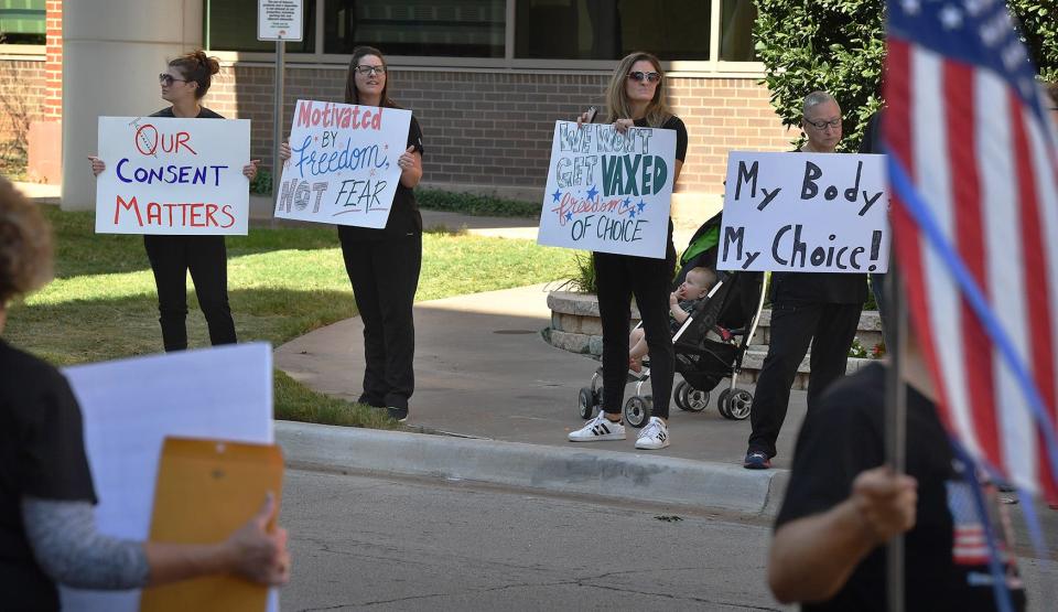 Demonstrators hold signs protesting vaccine mandates during a rally at United Regional Health Care System seen in this file photo. The crowd consisted of healthcare workers and others voicing their concerns.