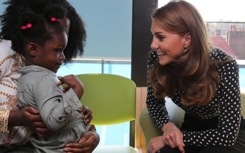 The Duchess of Cambridge talks to a child at the Sunshine House Centre yesterday - Credit: Ian Vogler/Reuters