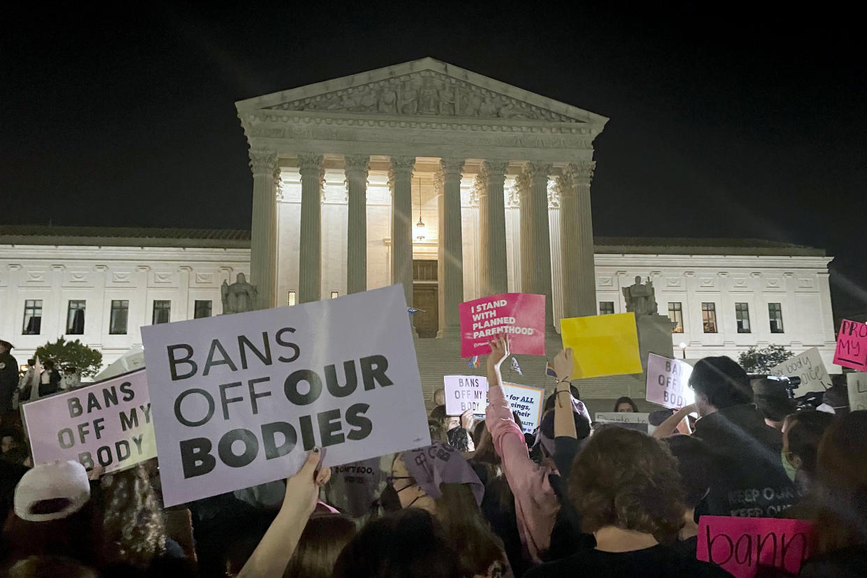 A crowd of people gather outside the Supreme Court on Monday night after publication of a draft opinion suggesting that the nation's high court is poised to overturn Roe v. Wade. (AP Photo/Anna Johnson)