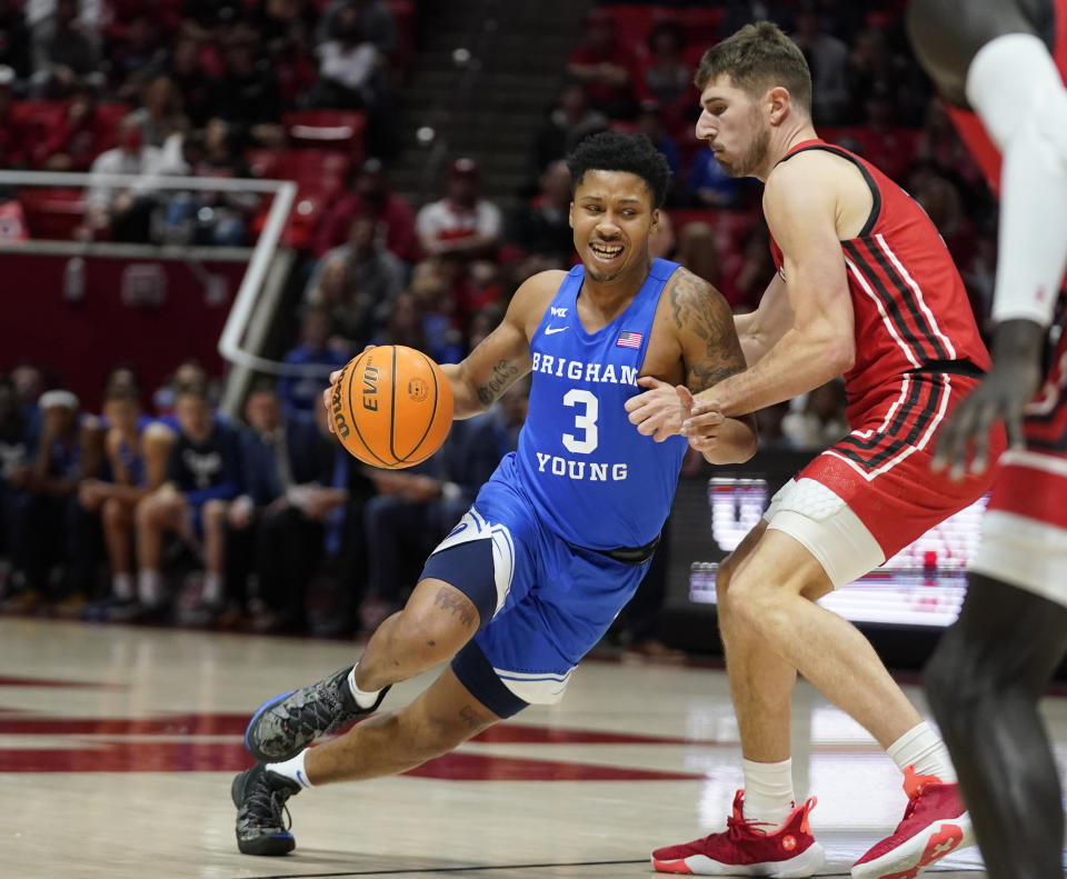 BYU guard Te'Jon Lucas (3) drives around Utah forward Riley Battin, right, in the first half during an NCAA college basketball game Saturday, Nov. 27, 2021, in Salt Lake City. (AP Photo/Rick Bowmer)