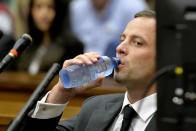 Oscar Pistorius drinks bottled water as he waits for the start of his trial at the high court in Pretoria, South Africa, Monday, March 3, 2014. Pistorius is charged with murder with premeditation in the shooting death of girlfriend Reeva Steenkamp in the pre-dawn hours of Valentine's Day 2013. (AP Photo/Herman Verwey, Pool)