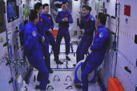 In this photo released by Xinhua News Agency, an image captured off a screen at the Jiuquan Satellite Launch Center in northwest China shows the Shenzhou-15 and Shenzhou-14 crew chatting after a historic gathering in space on Wednesday, Nov. 30, 2022. Three Chinese astronauts docked early Wednesday with their country's space station, where they will overlap for several days with the three-member crew already onboard and expand the facility to its maximum size. (Guo Zhongzheng/Xinhua via AP)