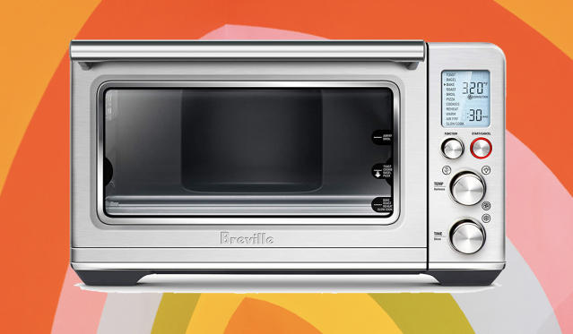 A stainless steel toaster oven on a rainbow background.