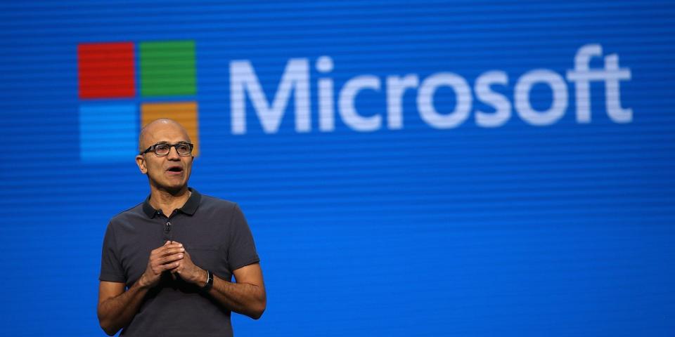 Microsoft CEO Satya Nadella with the word "Microsoft" and the Microsoft logo displayed behind him