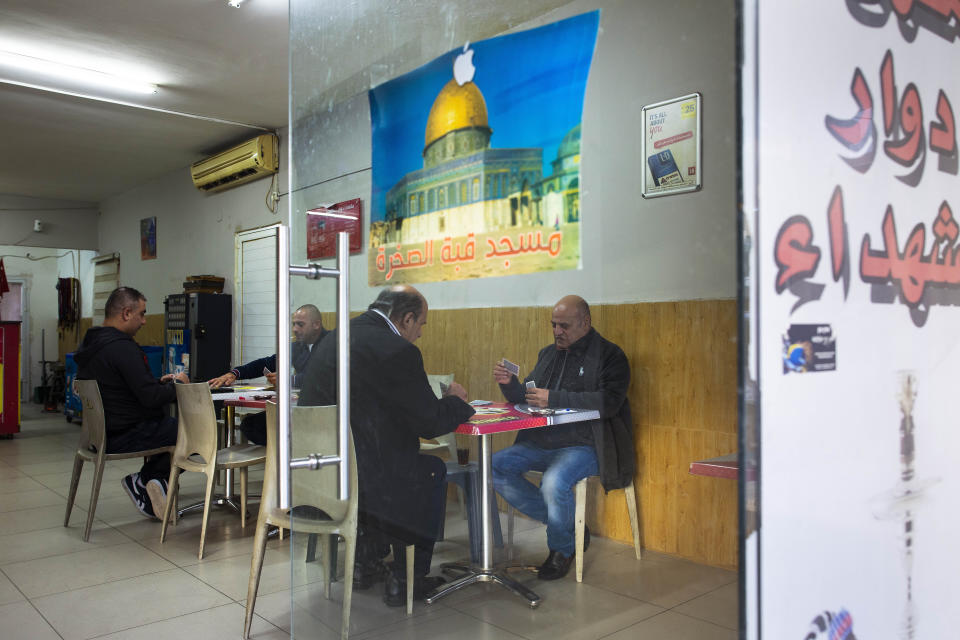 In this Thursday, Feb. 6, 2020, photo, Israeli Arabs play cards in a shop at the Israeli Arab town Kfar Qassem. President Donald Trump's Mideast initiative suggests that a densely populated Arab region of Israel could be added to a future Palestinian state, if both sides agree. The proposal has infuriated many of Israel's Arab citizens, who view it as a form of forced transfer. (AP Photo/Oded Balilty)