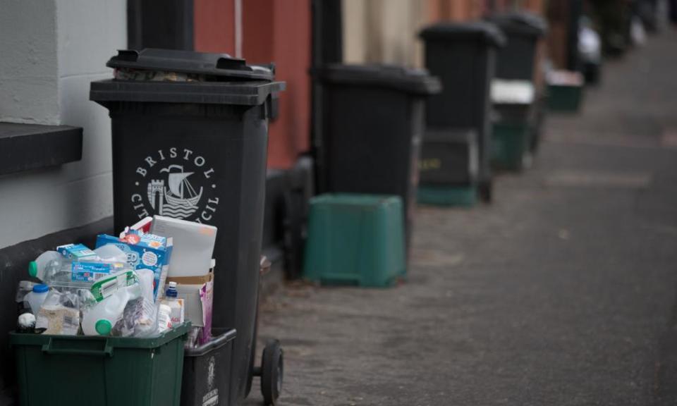 Rubbish in bins and recycling in boxes wait to be collected outside a residential property in Bristol, England.