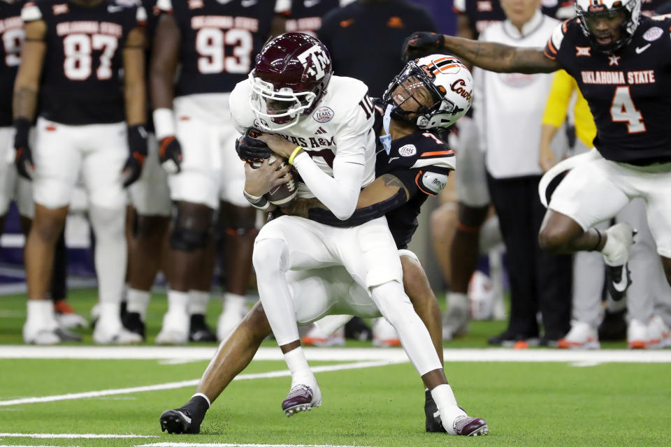 Texas A&M quarterback Marcel Reed, left, is caught on a keeper play by Oklahoma State safety Cameron Epps during the first half of the Texas Bowl NCAA college football game Wednesday, Dec. 27, 2023, in Houston. (AP Photo/Michael Wyke)