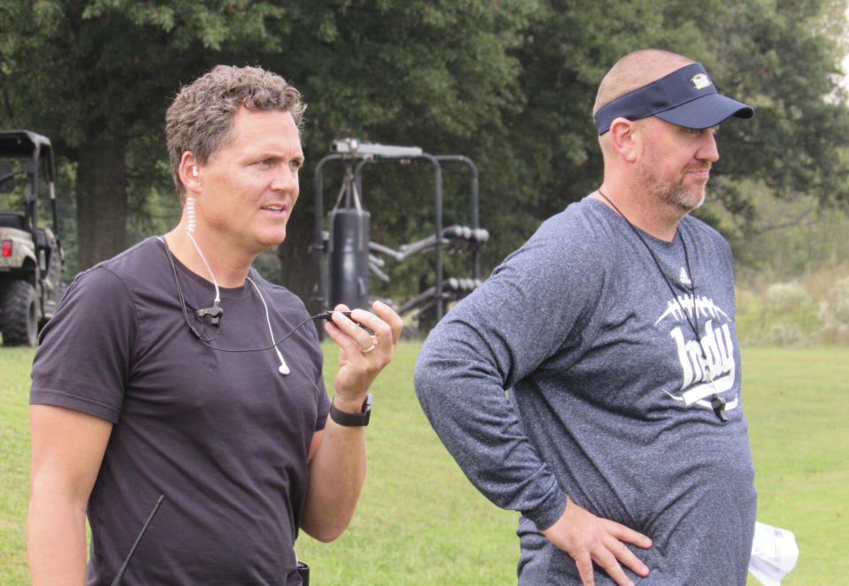 Last Chance U director Greg Whiteley and Independence Community College football coach Jason Brown watch a practice during a shoot for the Netflix series “Last Chance U.” in Independence, Kan. (Dion Lefler/The Wichita Eagle via AP)