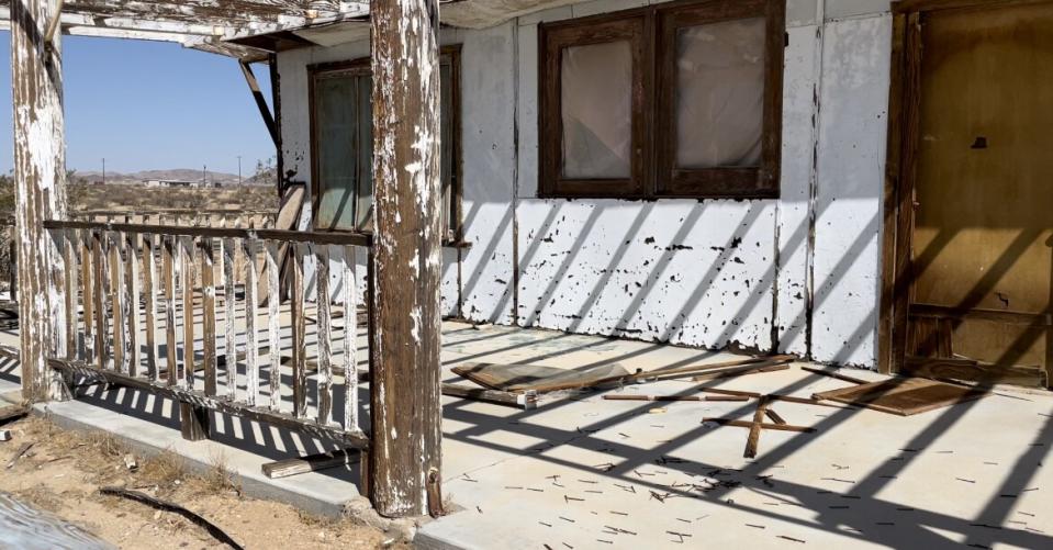 Nails scattered on the porch of a weathered house.