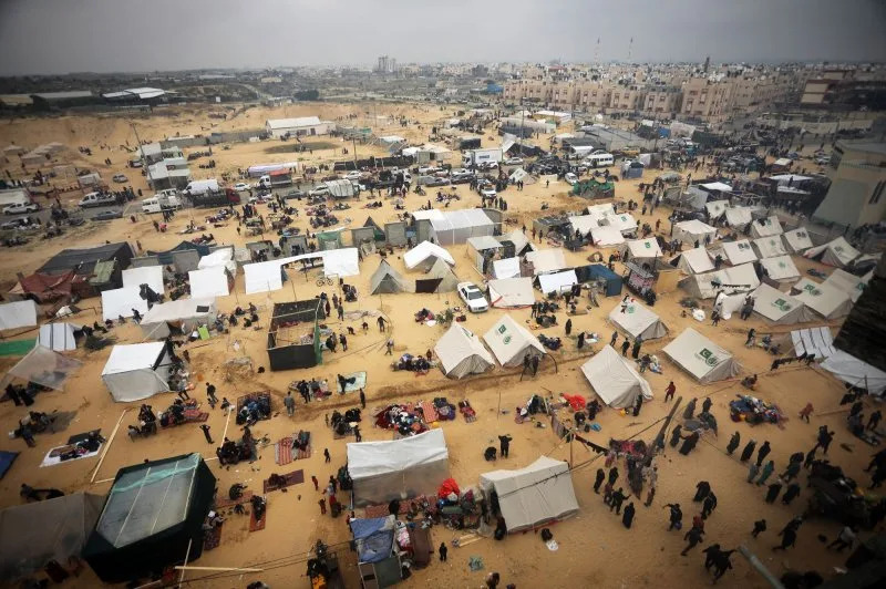 Displaced Palestinians who fled from Khan Younis sit outside makeshift shelters at a camp in Rafah, in the southern Gaza Strip, on Monday. Photo by Ismael Mohamad/UPI