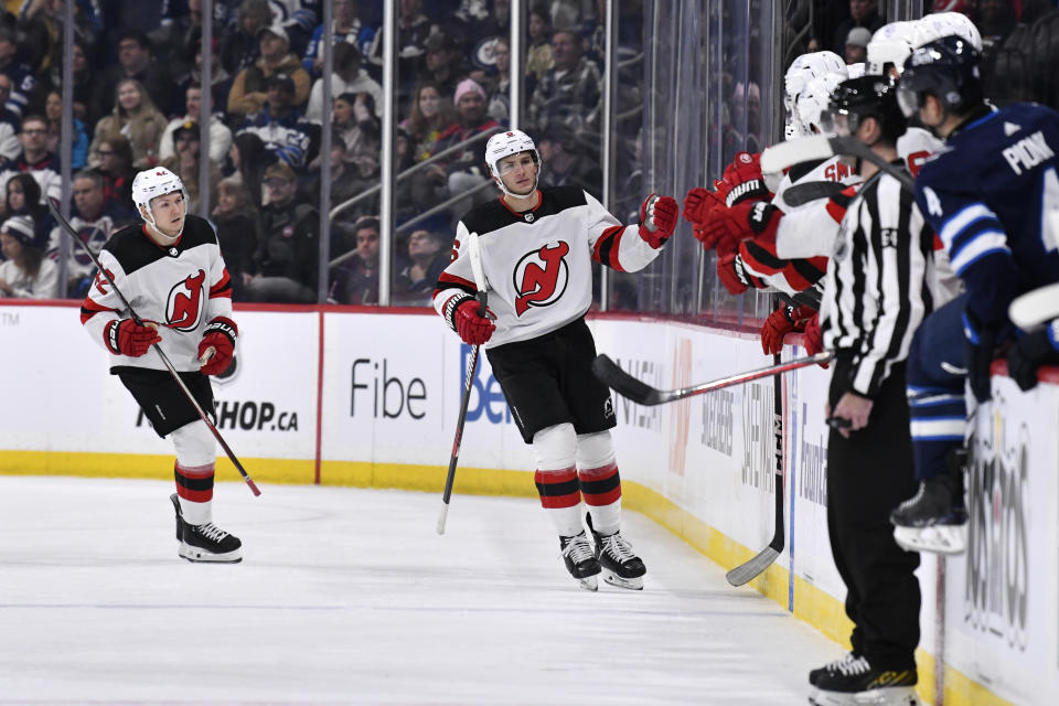 New Jersey Devils' John Marino (6) celebrates his goal against the Winnipeg Jets with teammates during the second period of an NHL hockey game Tuesday, Nov. 14, 2023, in Winnipeg, Manitoba. (Fred Greenslade/The Canadian Press via AP)