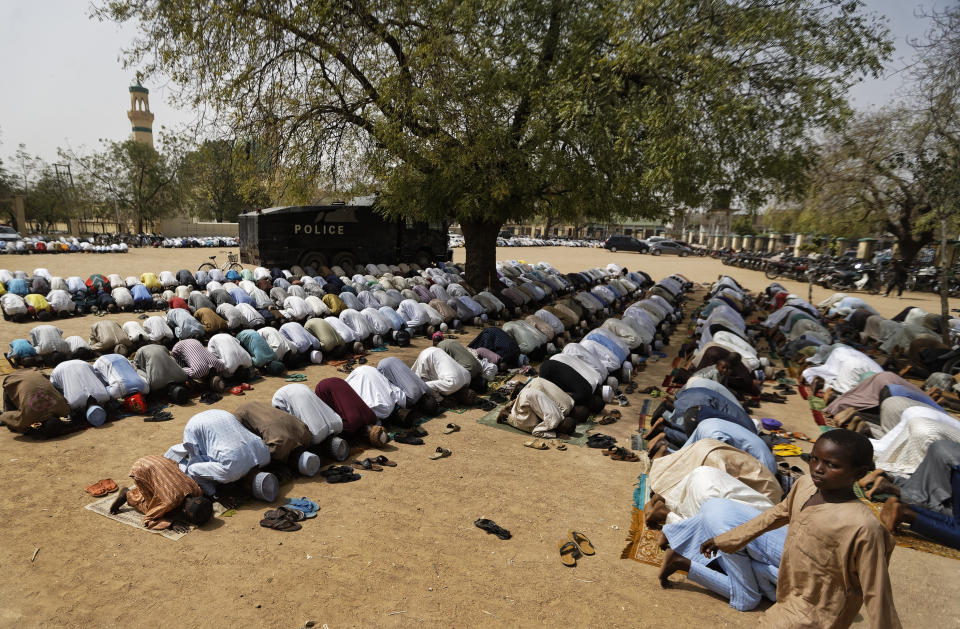 Muslims make traditional Friday prayers in front of a police riot truck, providing security due to the ongoing general threat of attacks by Islamic extremist group Boko Haram, at a mosque near to the Emir's palace in Kano, northern Nigeria Friday, Feb. 15, 2019. Nigeria is due to hold general elections on Saturday, pitting incumbent President Muhammadu Buhari against leading opposition presidential candidate Atiku Abubakar. (AP Photo/Ben Curtis)