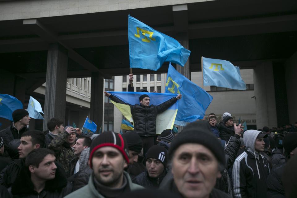 Crimean Tatars hold flags during rallies near the Crimean parliament building in Simferopol