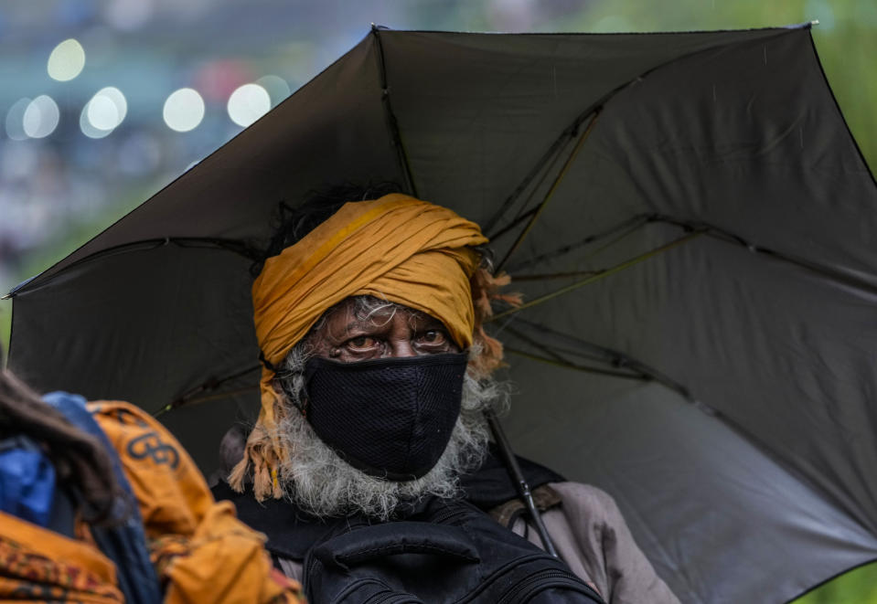 A Hindu pilgrim returns back after a cloudburst at Baltal, 105 kilometers (65miles) northeast of Srinagar, Indian controlled Kashmir, Saturday, July 9, 2022. More than ten pilgrims have been killed and many feared missing after a cloudburst triggered a flash flooding during an annual Hindu pilgrimage to an icy Himalayan cave in Indian-controlled Kashmir. Officials say the cloudburst near the hollowed mountain cave revered by Hindus on Friday sent a wall of water down a mountain gorge and swept about two dozen encampments and two makeshift kitchens. (AP Photo/Mukhtar Khan)