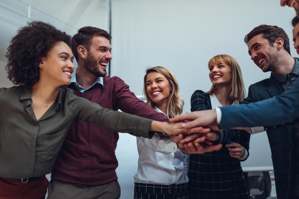 Close up of a group of businesspeople stacking their hands on top of each other