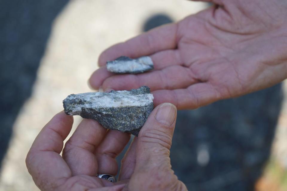 A member of HOMEWhatcom holds up a piece of gravel on Sept. 1, 2023, that was extracted from the site of the proposed Ranch Quarry Mine. Residents living near the proposed site are worried about the possibility of asbestos in the rocks.