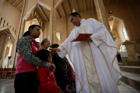 Priest Tomas Martinez blesses women whose relatives are missing during a Mass for mothers of missing persons on Mother's Day in Chilapa de Alvarez, in the state of Guerrero, Mexico May 10, 2018. REUTERS/Daniel Becerril