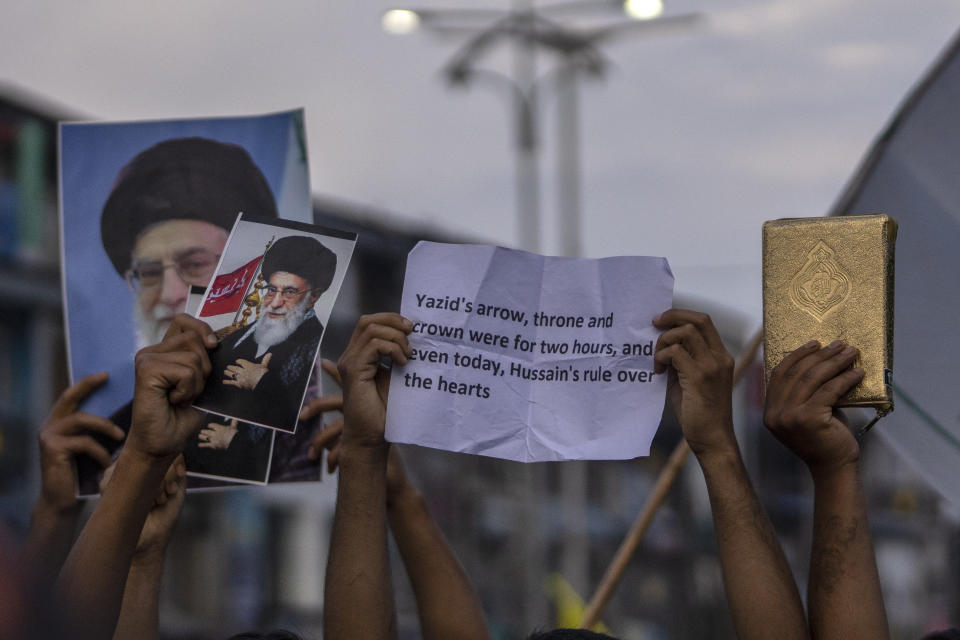 A Kashmiri Shiite Muslim, right, holds a copy of the Quran as others carry posters of Iran's supreme leader Ayatollah Ali Khamenei during a Muharram procession in Srinagar, Indian controlled Kashmir, Thursday, July 27, 2023. Muharram is a month of mourning for Shiite Muslims in remembrance of the martyrdom of Imam Hussein, the grandson of the Prophet Muhammad. (AP Photo/Dar Yasin)