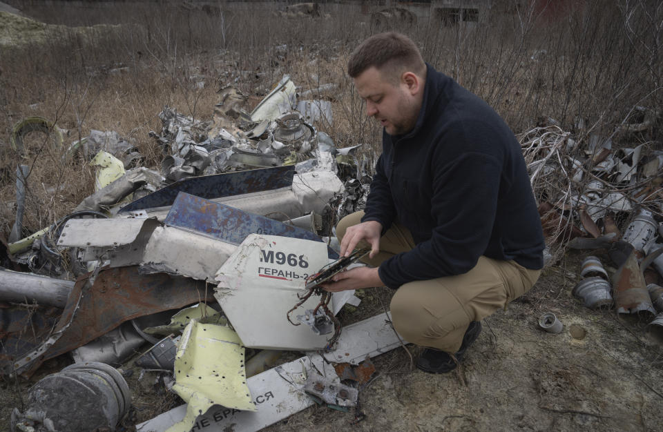 A prosecutor examines fragments of Russian missiles and drones that were collected to investigate Russia's military crimes in Kharkiv, Ukraine, Monday, March 18, 2024. (AP Photo/Efrem Lukatsky)