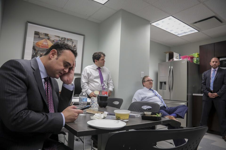 Adam Slater consulta su teléfono durante una reunión con otros abogados de su estudio de Melville, Nueva York, el 29 de octubre del 2019. Slater representa a 300 personas que dicen haber sido víctimas de abusos sexuales de curas. (AP Photo/Bebeto Matthews)