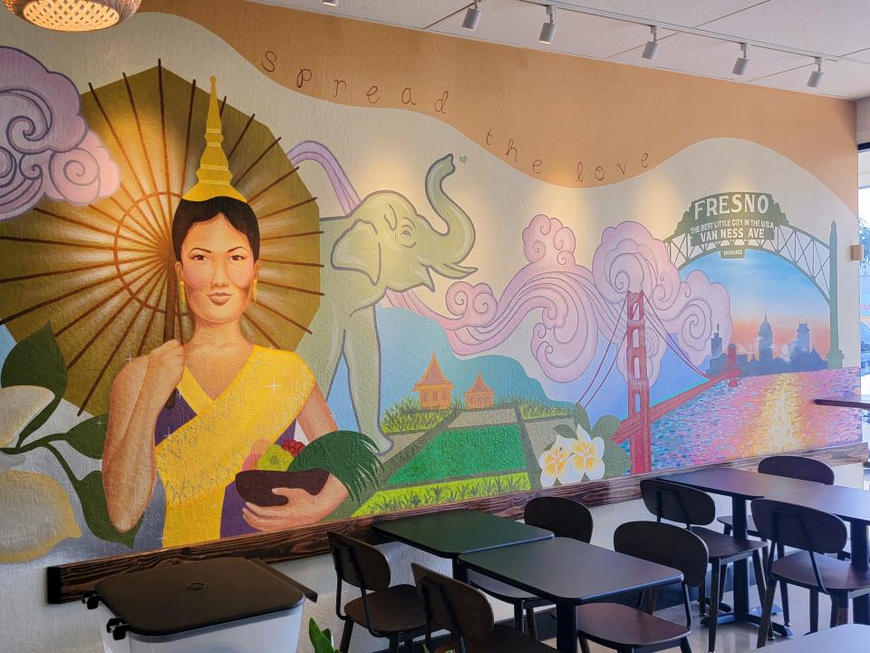 A mural at the Fresno restaurant Love & Thai depicts a Laotian woman net to rice fields and the Golden Gate Bridge