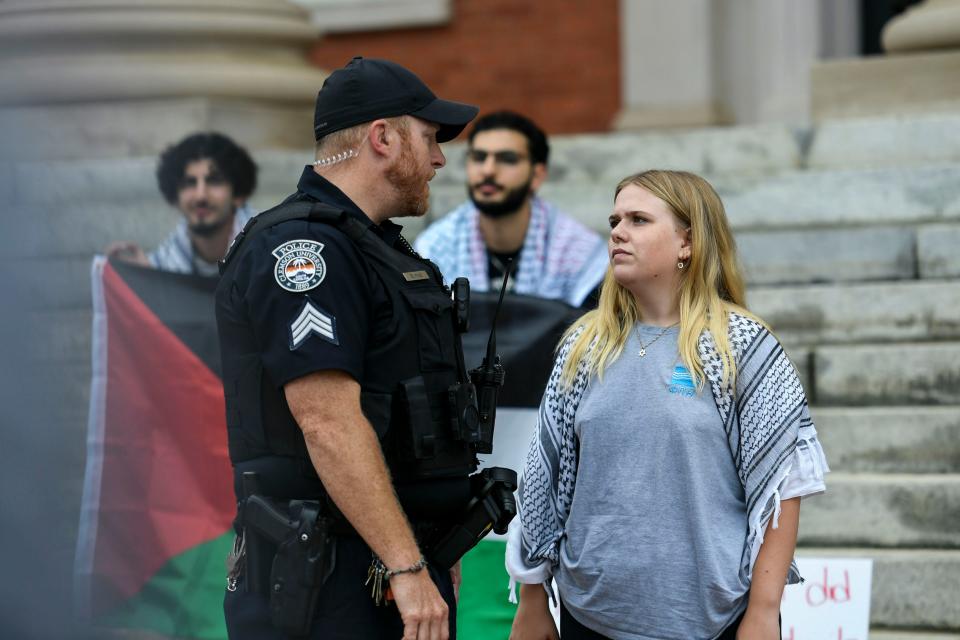 Abigail Friedman, 20, a Clemson University student, Palestinian supporter and protest organizer, speaks with a police officer during the protest outside of Sikes Hall at Clemson University on Saturday, May 4, 2024.